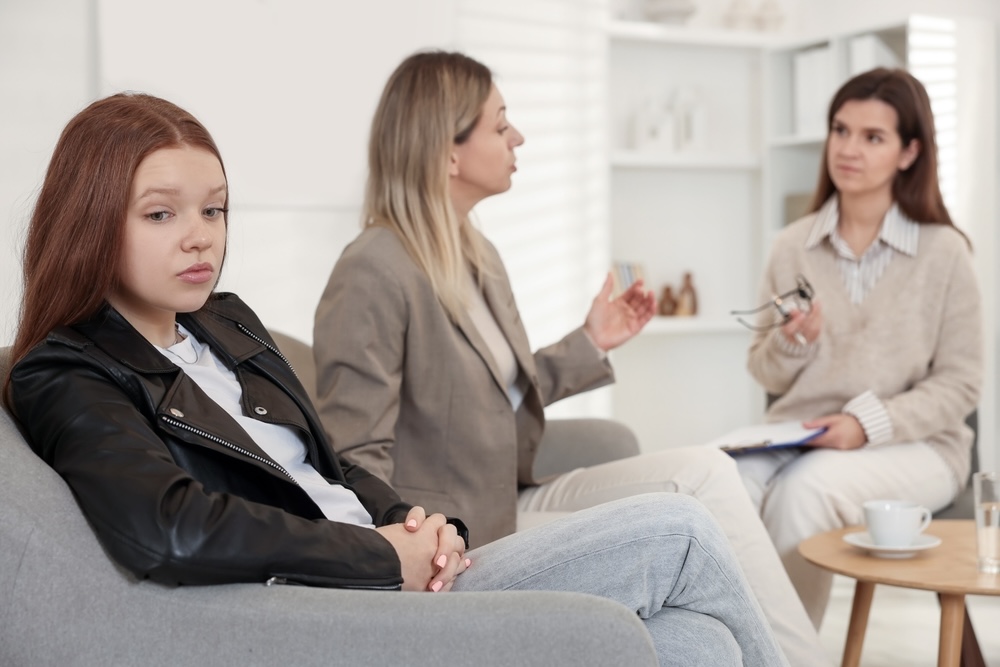 Mother speaking to a psychologist during family therapy for mental health