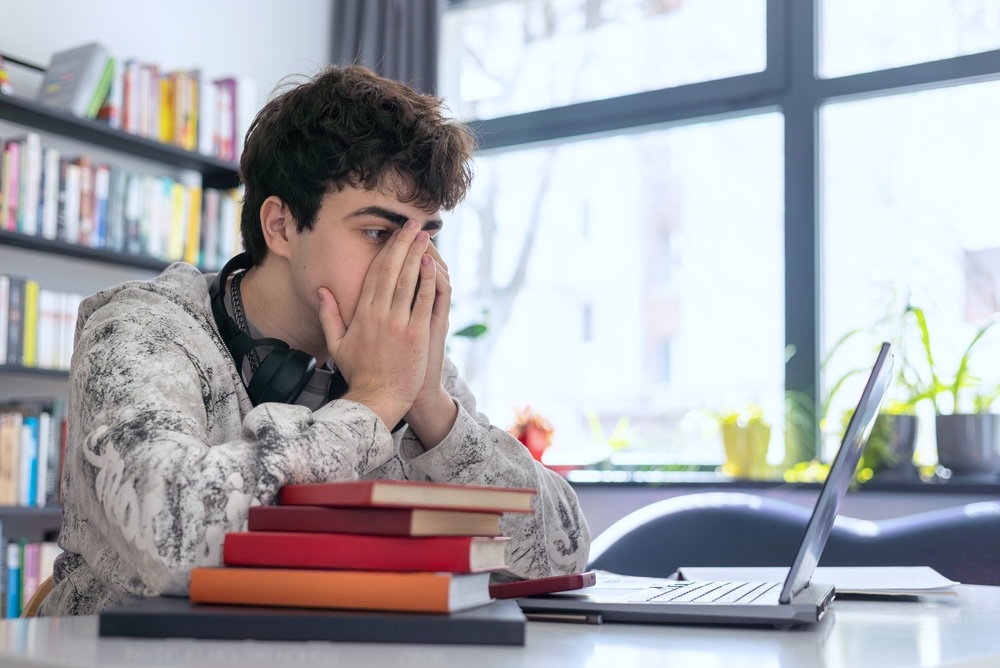Male teenager in residential mental health treatment studying
